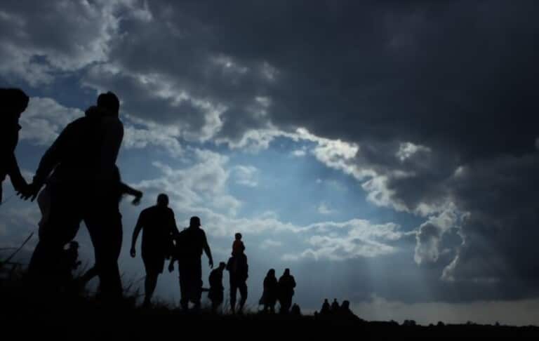 caravan of migrants in the dark