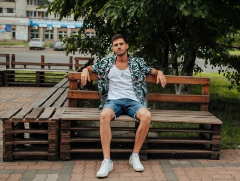 young man wearing hawaiian shirt combined with white t-shirt sitting at the park young man wearing hawaiian shirt combined with white t-shirt sitting at the park