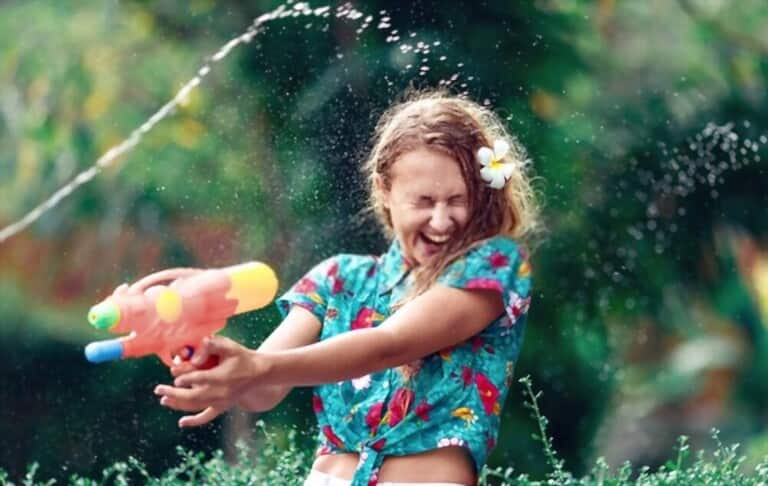 a girl wearing tying hawaiian shirt who is funny with water splashing game a girl wearing tying hawaiian shirt who is funny with water splashing game
