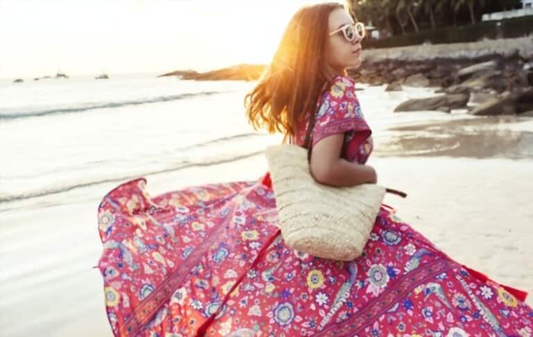 a young girl wearing maxi dress with tropical prints on the beach
