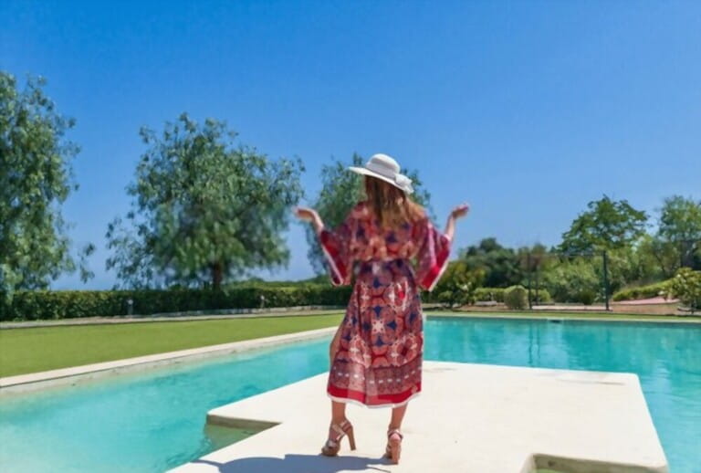 Blonde girl posing in summer with a dress by the pool