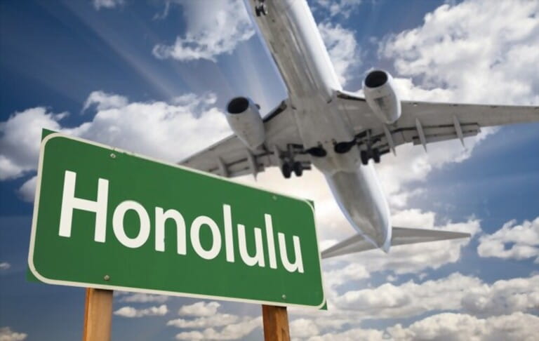 Honolulu Green Road Sign and Airplane Above with Dramatic Blue Sky and Clouds.