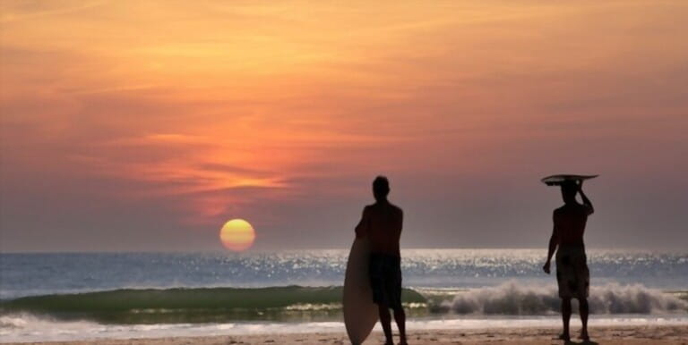 two surfers wainting for the wave in Cocoa Beach, Florida, usa, at sunset