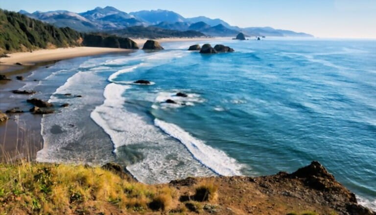 Sweeping view of the Oregon coast, miles of white sandy beaches, sea stacks and ocean waves. Location: Cliff's edge at Ecola Park overlook in the Pacific Northwest, USA Sweeping view of the Oregon coast, miles of white sandy beaches, sea stacks and ocean waves. Location: Cliff's edge at Ecola Park overlook in the Pacific Northwest, USA