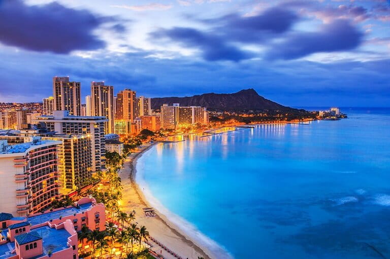Aerial shot of Honolulu Hawaii at night- a well-lit city with stunning sea views