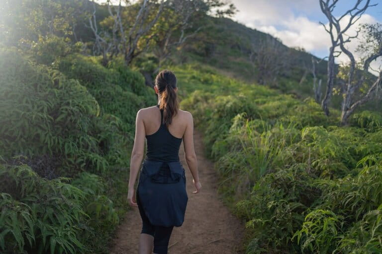 Female hiker following a trail through the rainforest Female hiker following a trail through the rainforest