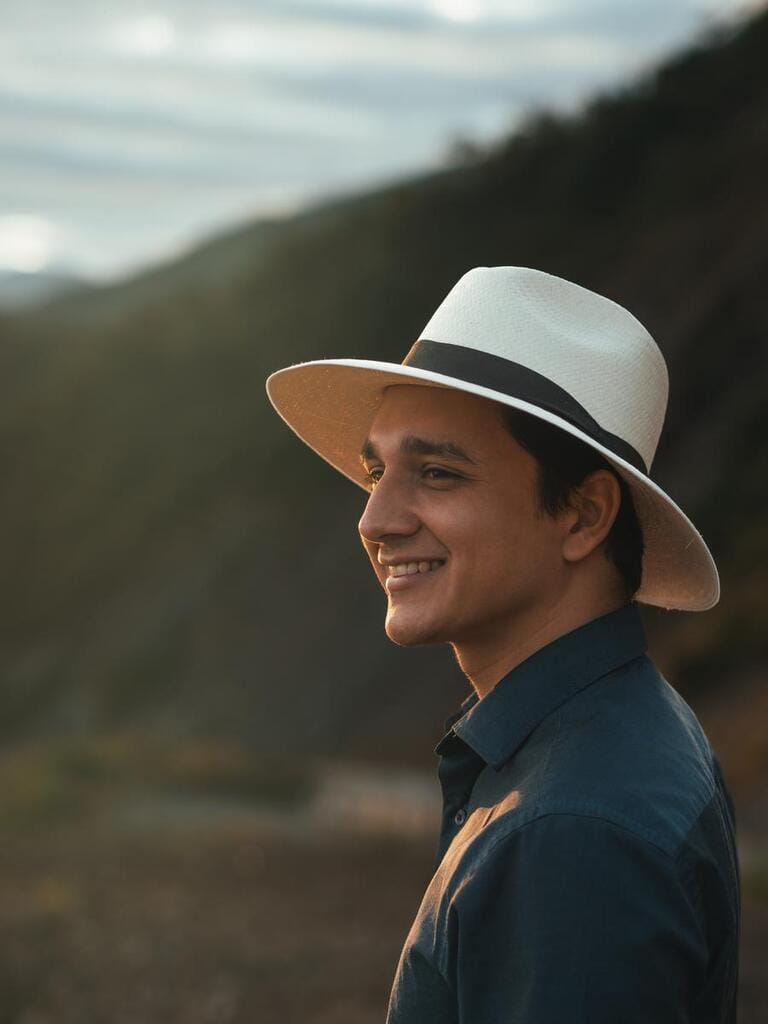 young man on vacation in the ecuadorian highlands smiles wearing his toquilla straw hat, the panama hat, made in Montecristi - ecuador
