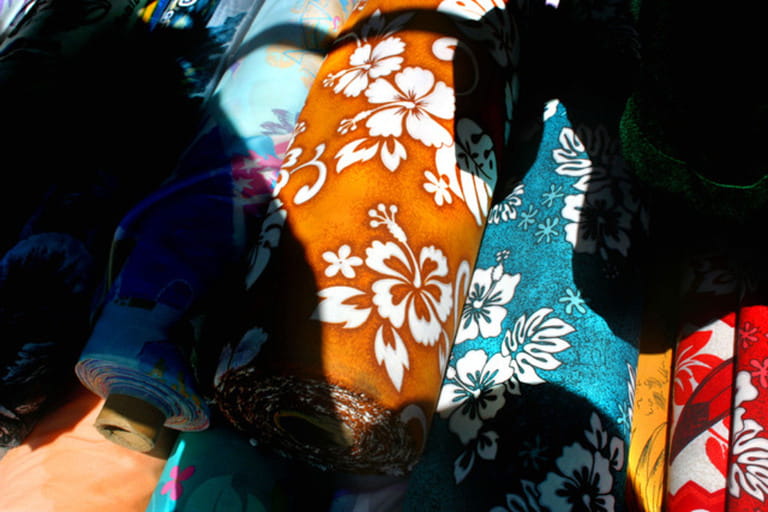 Rolls of Hawaiian shirt fabrics and patterns are displayed for sale at the Aloha Bowl Flea Market Rolls of Hawaiian shirt fabrics and patterns are displayed for sale at the Aloha Bowl Flea Market