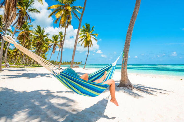 Canto de la Playa, Saona Island, East National Park (Parque Nacional del Este), Dominican Republic, Caribbean Sea. Woman relaxing on a hammock on the beach