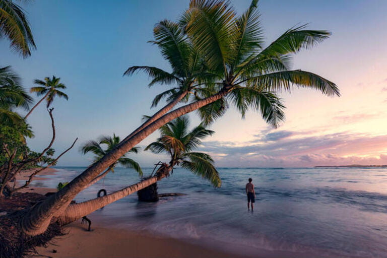 Man on a deserted wild beach at sunrise on the Caribbean island Puerto Rico