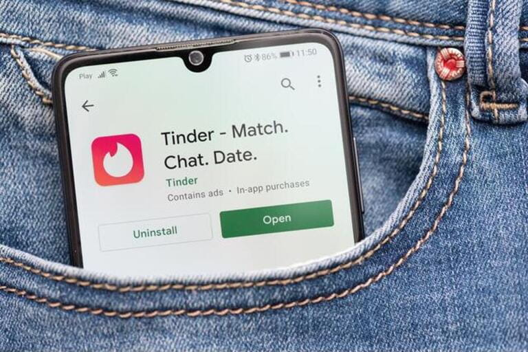 Tinder logo on smartphone in pocket. Tinder is most popular dating app