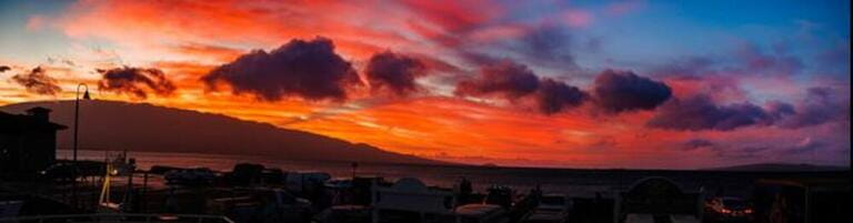 The view from Maalaea Boat Harbor of sunrise over Haleakala, Maui's dormant volcano, with Kahoolawe on the far right, Hawaii.