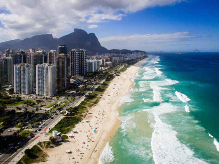 Drone photo of Barra da Tijuca beach, Rio de Janeiro, Brazil. We can see the beach, some building, the boardwalk, the road and the horizon