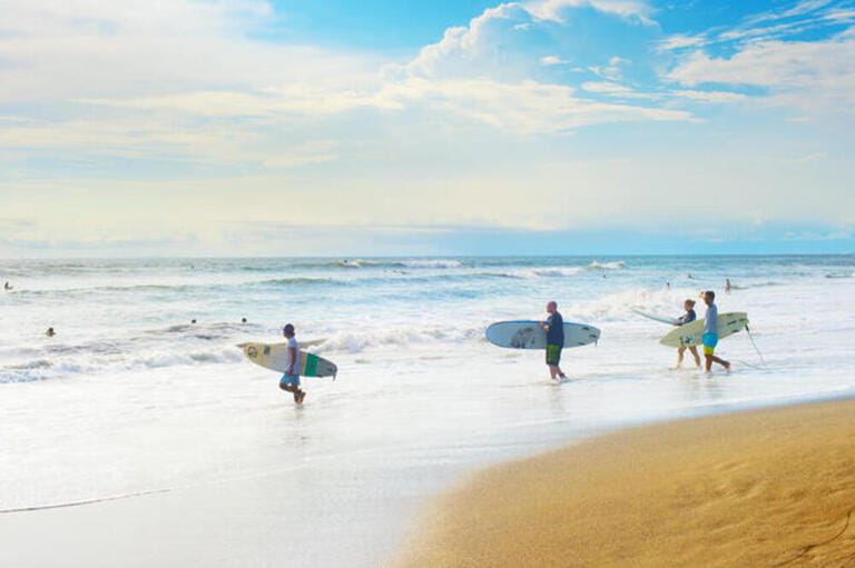Group of surfers going to surf on the beach. Bali island is one of the worlds best surfing destinations Group of surfers going to surf on the beach. Bali island is one of the worlds best surfing destinations