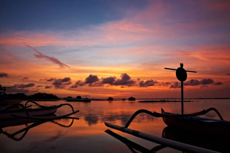 sunset over traditional fishing boats on Bali, Indonesia
