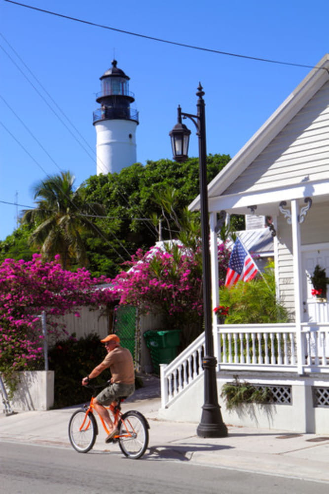 Florida Key West Florida,Keys Truman Avenue,man men male adult adults,bicycle,bicycling,riding,biking,rider,riding,lamppost,Key West Lighthouse,visito