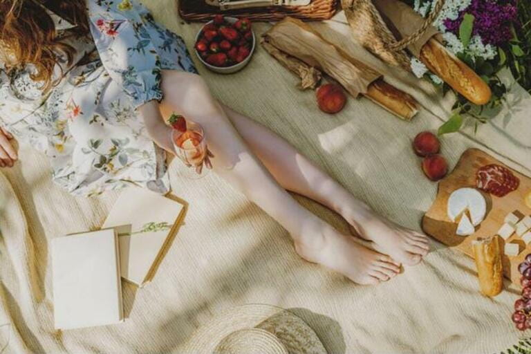Beautiful legs of young woman in white sitting on blanket and having picnic. Beautiful legs of young woman in white sitting on blanket and having picnic.