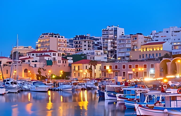 View of Heraklion city with harbour with yachts and fishing boats at dusk, Crete island, Greece. Greek scenery View of Heraklion city with harbour with yachts and fishing boats at dusk, Crete island, Greece. Greek scenery