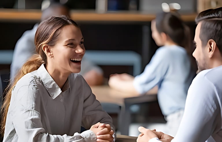 Smiling millennial man and woman sit at table in cafe talking getting acquainted laughing having fun together, happy young people colleagues hanging out in bar, excited couple on date in restaurant Smiling millennial man and woman sit at table in cafe talking getting acquainted laughing having fun together, happy young people colleagues hanging out in bar, excited couple on date in restaurant