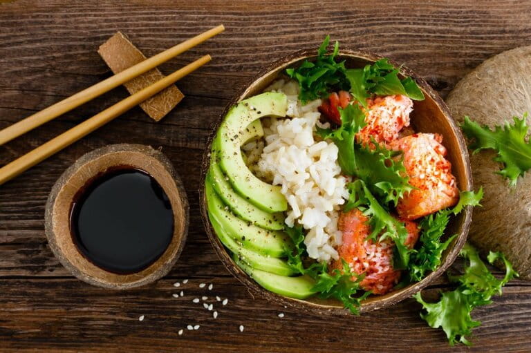 Hawaiian poke coconut bowl with grilled salmon, rice and avocado. Healthy food.