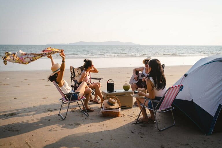 Group of Asian friends having fun enjoying beach camping in summer Group of Asian friends having fun enjoying beach camping in summer