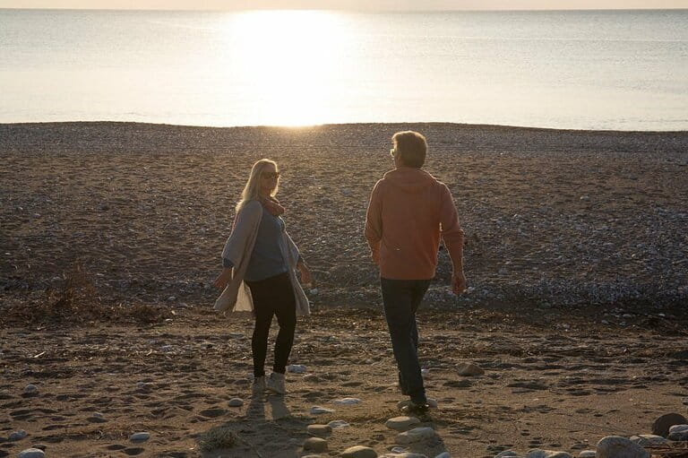The couple walked onto the empty beach at dawn, full of life The couple walked onto the empty beach at dawn, full of life