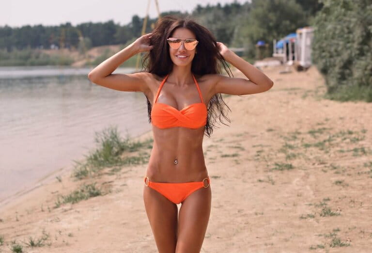 Beautiful sexy brunette smiling woman wearing bikini close up outdoors